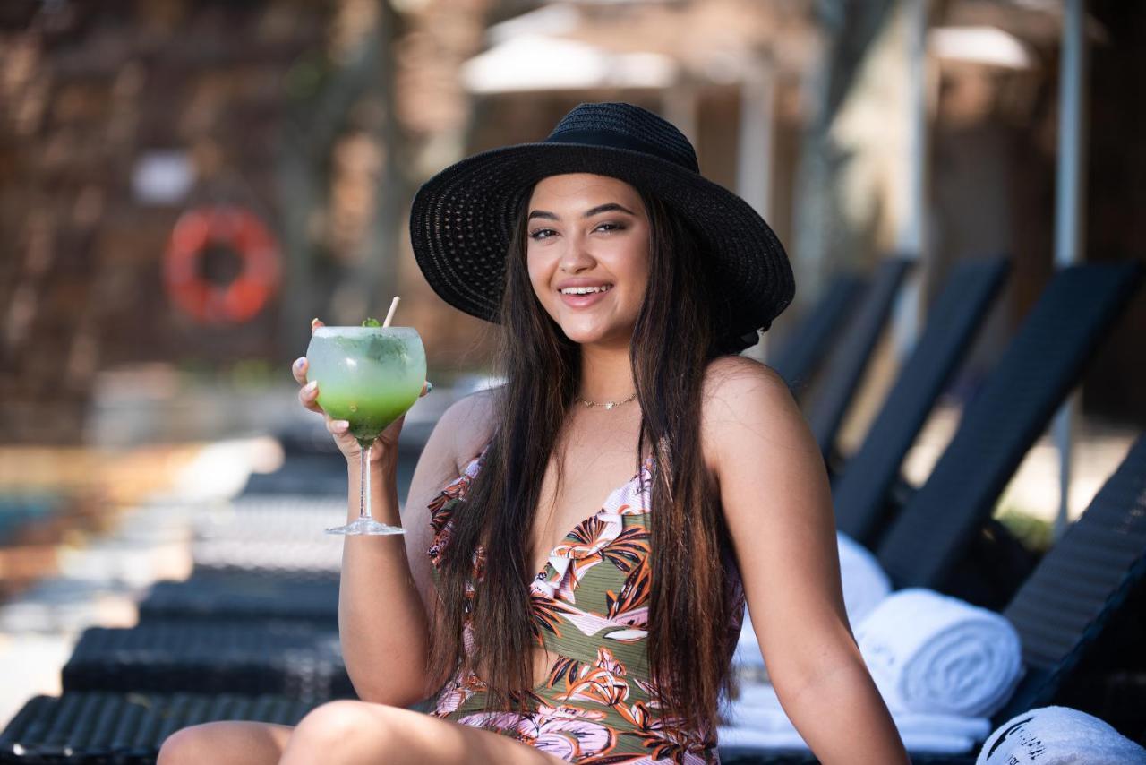 Hotel The Capital Zimbali Ballito Esterno foto A woman wearing a sun hat