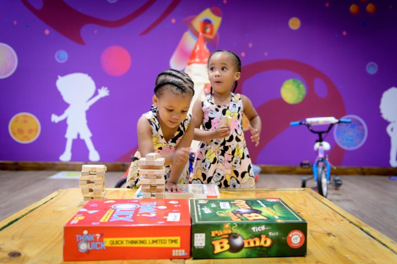 Hotel The Capital Zimbali Ballito Esterno foto Two children playing with board games